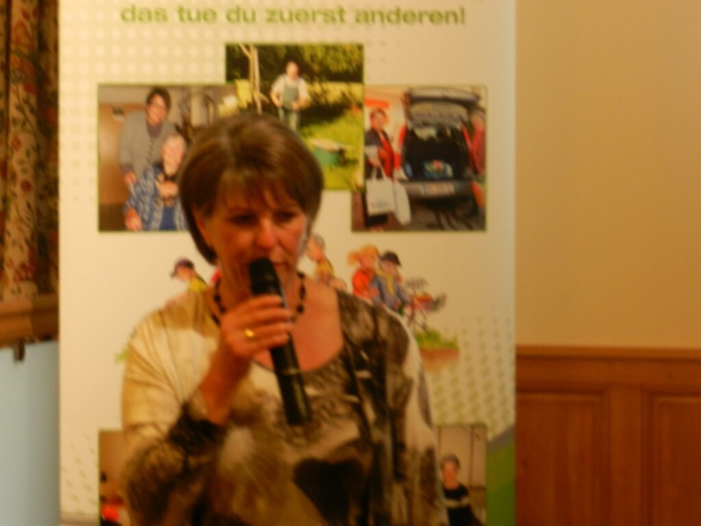 Frau spricht bei einer Veranstaltung der Zeitbank Eggelsberg in ein Mikrofon