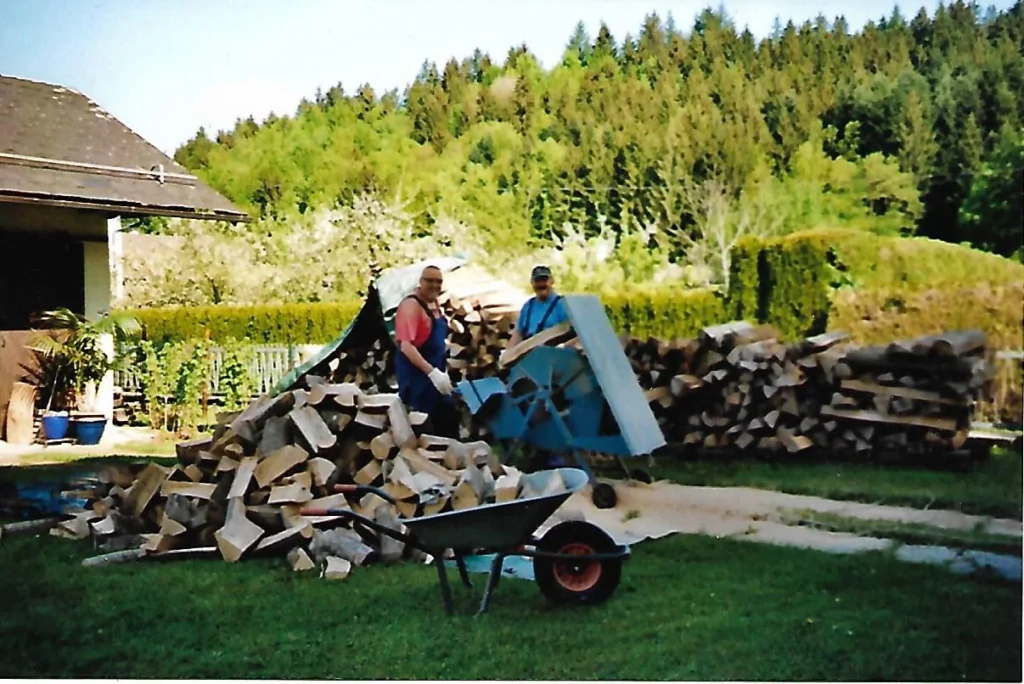 Zwei Personen arbeiten an einem Holzspalter im Garten