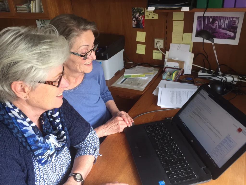 Zwei Frauen arbeiten gemeinsam an einem Laptop